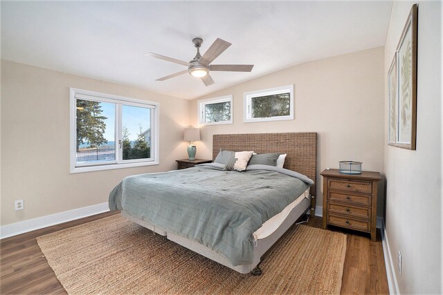 bedroom featuring a ceiling fan, lofted ceiling, wood finished floors, and baseboards