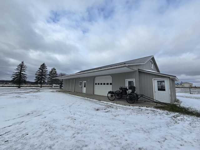 snow covered garage featuring a detached garage