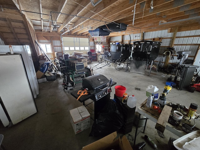 garage with a garage door opener and freestanding refrigerator