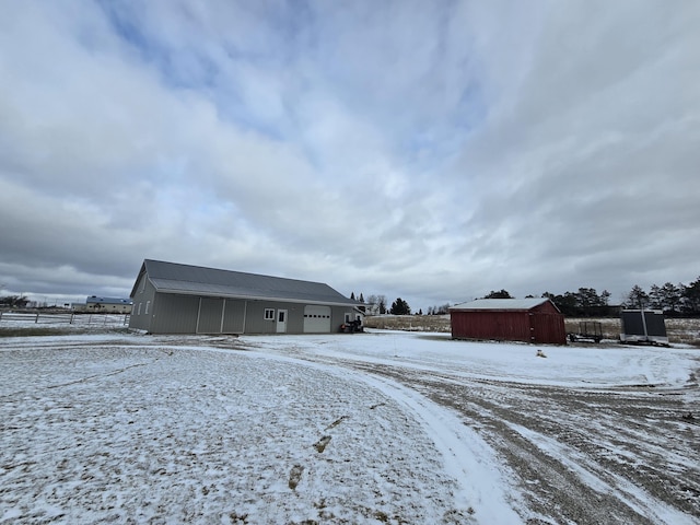 snow covered structure featuring an outbuilding