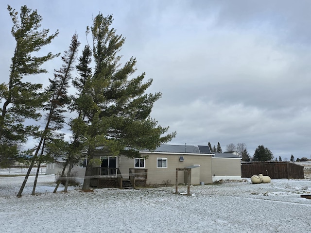 rear view of house with a deck and fence