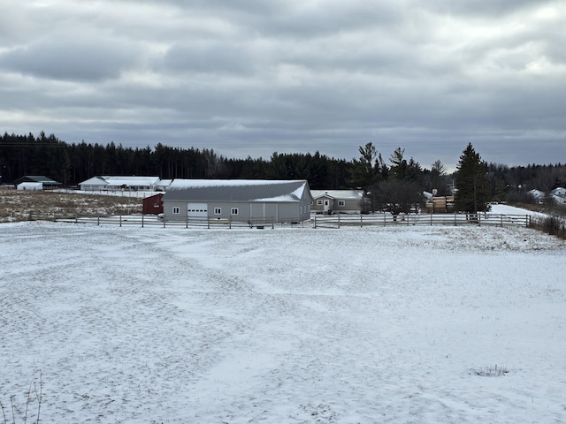 yard covered in snow featuring an outbuilding and fence