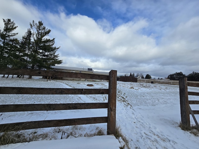 snowy yard featuring fence