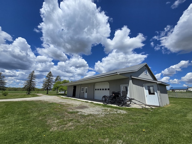 440 N Galbraith Rd, Mio, MI 48647 - view of side of home featuring a yard, a garage, dirt driveway, an outdoor structure, and metal roof