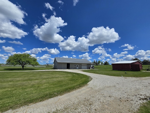440 N Galbraith Rd, Mio, MI 48647 - single story home featuring an attached garage, curved driveway, a front lawn, a pole building, and an outbuilding