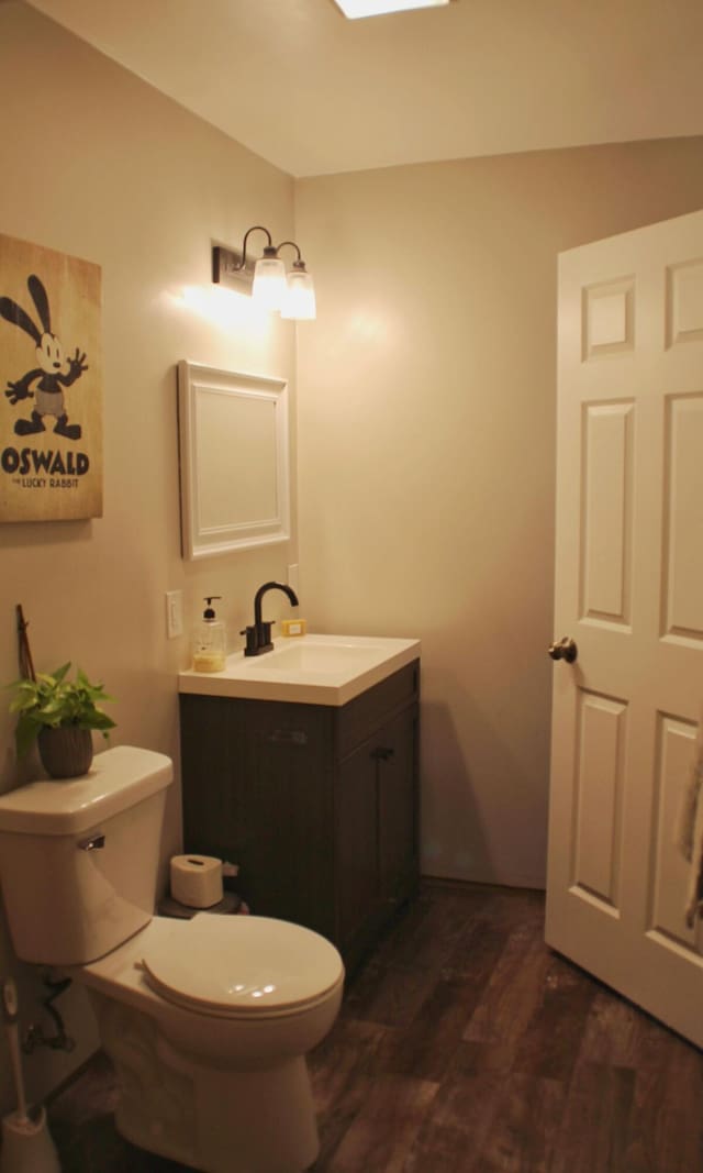 bathroom with vanity, toilet, and wood finished floors