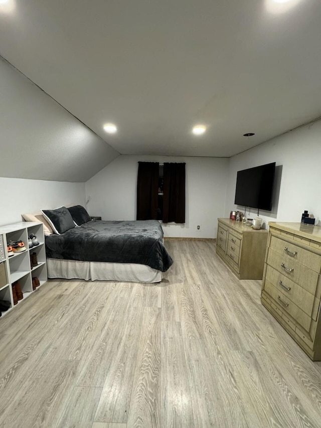 bedroom with lofted ceiling and light wood-style flooring