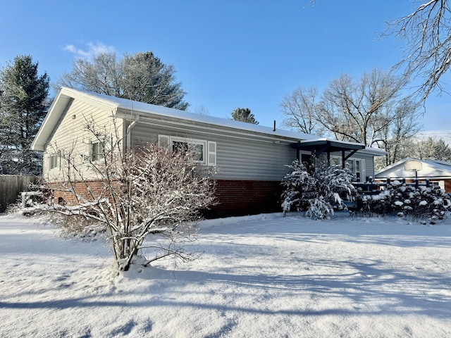 view of snow covered back of property