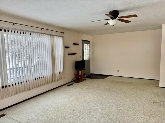 unfurnished living room with ceiling fan, carpet, and a textured ceiling