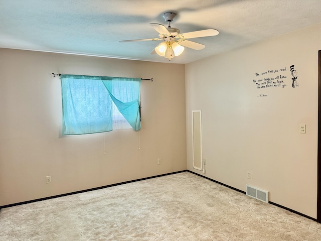 unfurnished room featuring a textured ceiling, carpet, visible vents, and ceiling fan