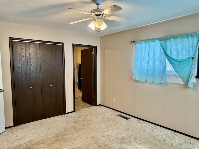 unfurnished bedroom featuring visible vents, ceiling fan, baseboards, carpet, and a closet