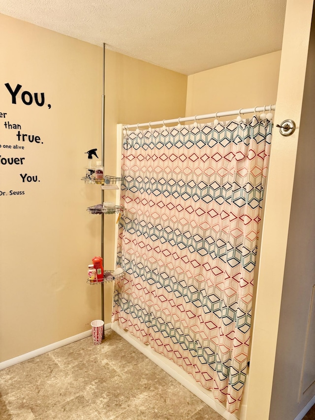 full bathroom with curtained shower and a textured ceiling