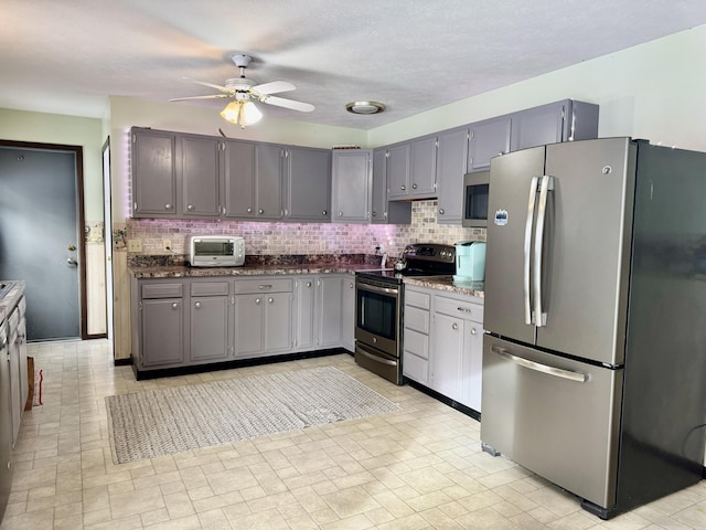 kitchen with decorative backsplash, gray cabinetry, and stainless steel appliances