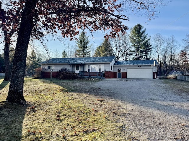 single story home featuring brick siding, a front lawn, fence, a garage, and driveway