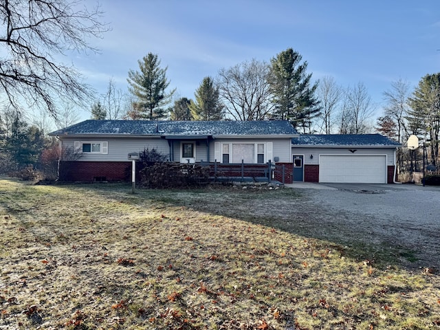 view of front of house featuring a front lawn, an attached garage, brick siding, and driveway