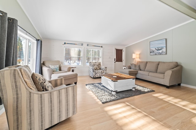 living room with a healthy amount of sunlight, lofted ceiling, and wood finished floors