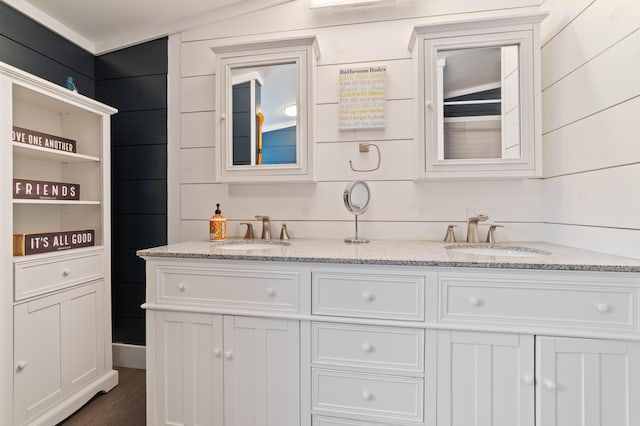 full bathroom featuring double vanity, wood finished floors, and a sink