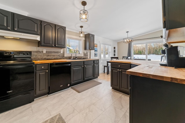 kitchen featuring a sink, butcher block countertops, black appliances, under cabinet range hood, and crown molding