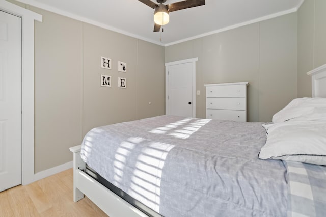 bedroom featuring light wood-type flooring, crown molding, and ceiling fan