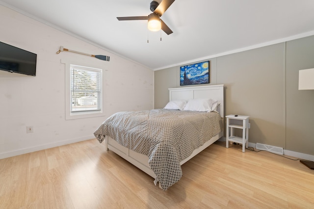 bedroom with light wood finished floors, visible vents, ceiling fan, baseboards, and lofted ceiling