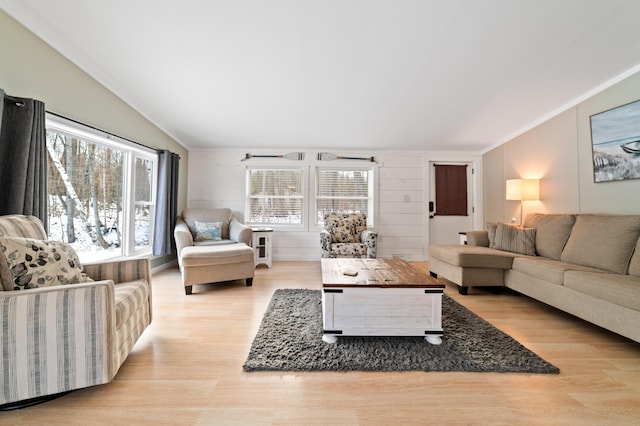 living room featuring lofted ceiling, wood finished floors, and ornamental molding