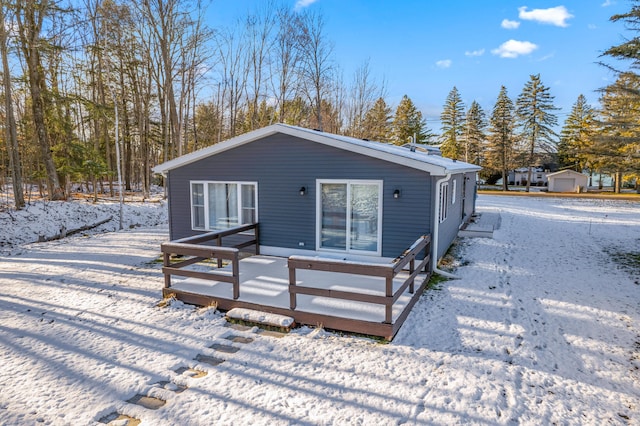 snow covered house with a wooden deck