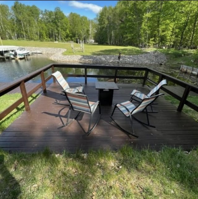 wooden terrace with a forest view and a water view