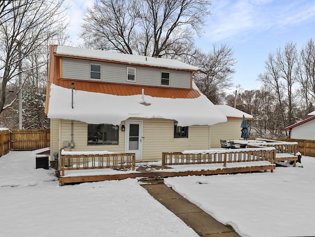 snow covered property featuring covered porch and fence