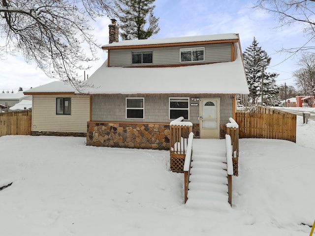 view of front of property with a chimney and fence