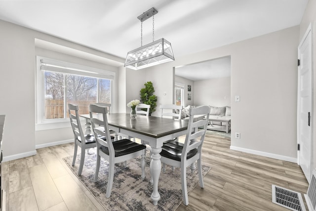 dining room with visible vents, baseboards, a healthy amount of sunlight, and light wood finished floors