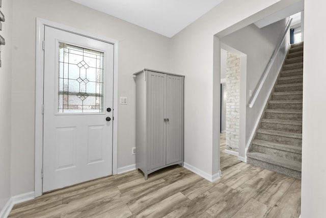 entrance foyer with a wealth of natural light, stairway, and light wood-style flooring