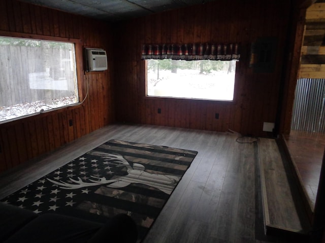 spare room with wooden walls, wood finished floors, and a wall mounted AC