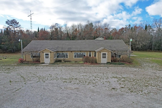 view of front of house featuring a chimney and a shingled roof