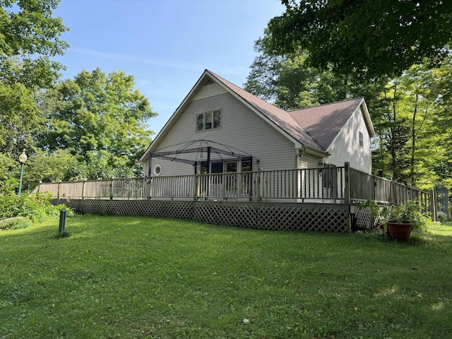 rear view of property featuring a yard and a wooden deck