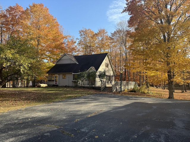 view of side of home featuring driveway and a deck