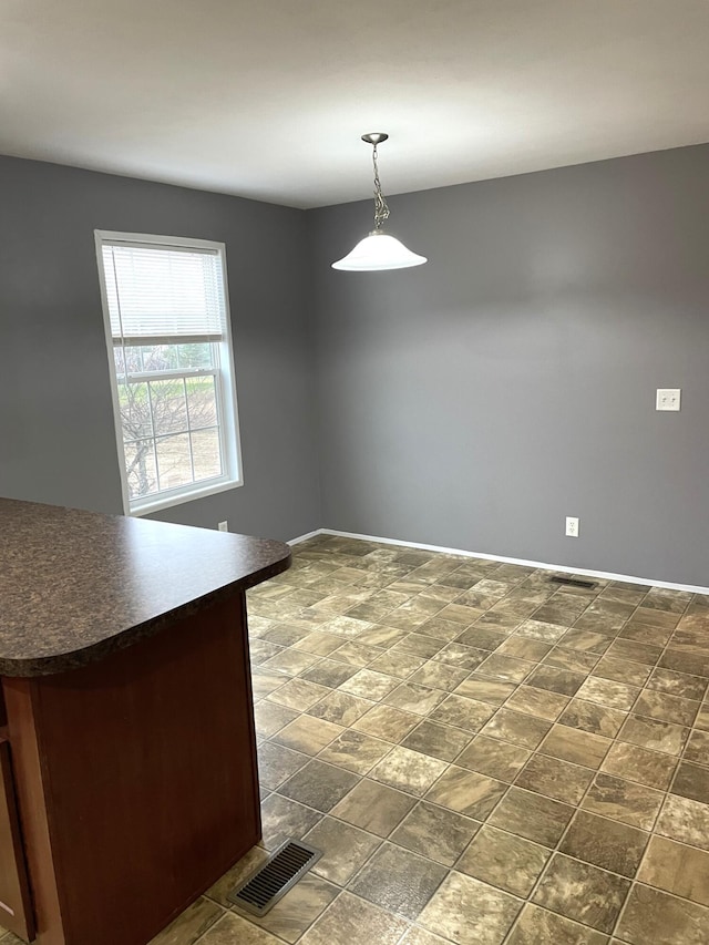 unfurnished dining area with visible vents and baseboards