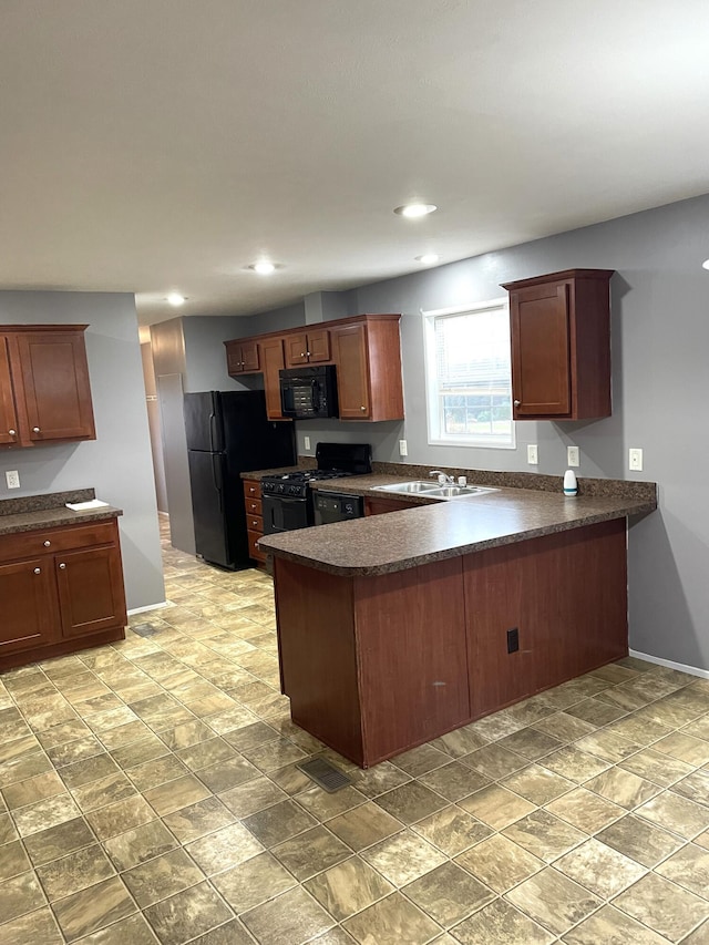 kitchen with black appliances, dark countertops, and a peninsula