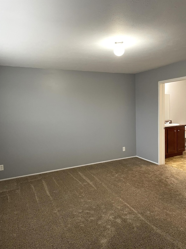 spare room with carpet and a textured ceiling