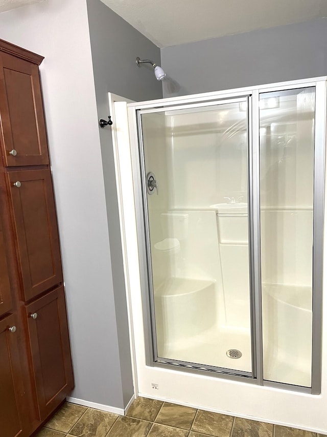 bathroom featuring baseboards and a stall shower