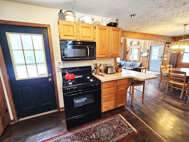 kitchen featuring a notable chandelier, black appliances, a textured ceiling, dark wood-style floors, and light countertops