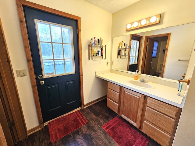 bathroom featuring vanity, wood finished floors, baseboards, a textured ceiling, and toilet