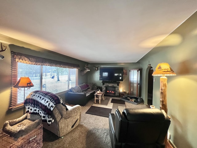 carpeted living area featuring a glass covered fireplace