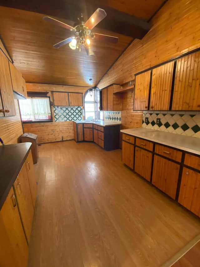 kitchen featuring wooden ceiling, light wood-style flooring, vaulted ceiling with beams, and brown cabinets