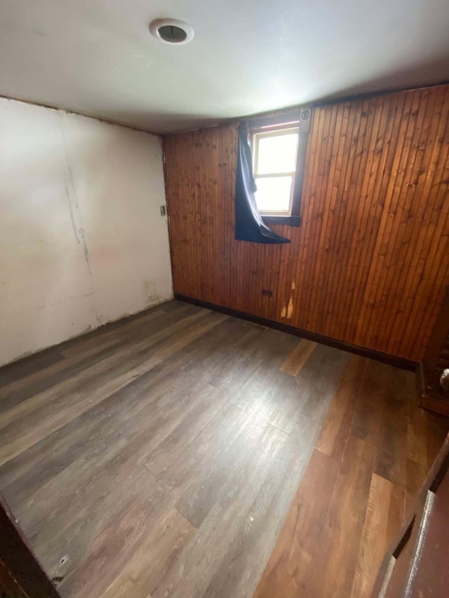 spare room with wood walls and wood finished floors