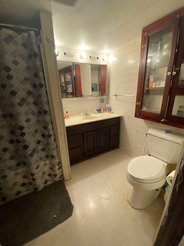 full bathroom featuring curtained shower, tile walls, toilet, and vanity