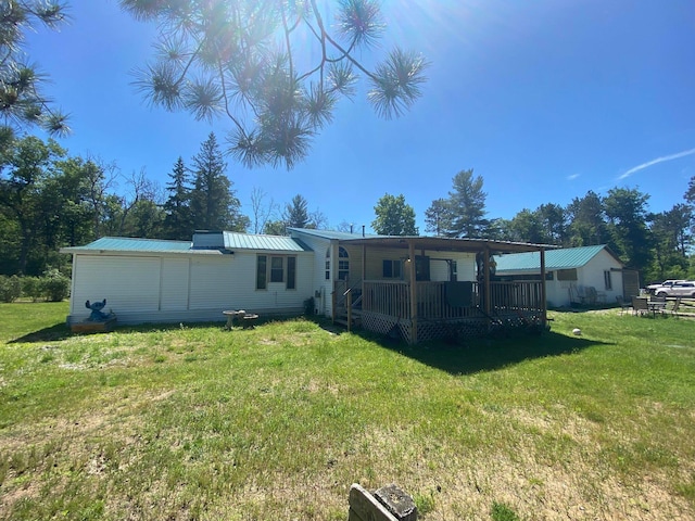 rear view of property featuring metal roof and a lawn