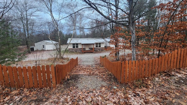 view of yard with a fenced front yard, covered porch, and an outdoor structure