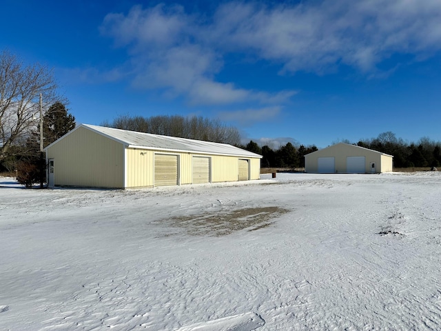 snow covered garage with a detached garage