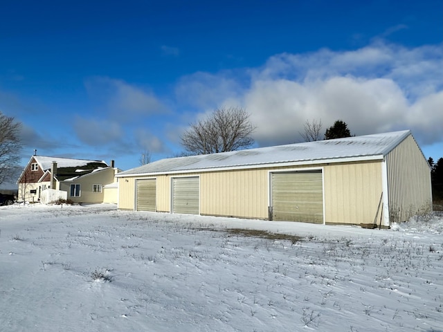 snow covered garage with a garage