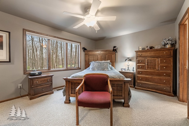 bedroom featuring light colored carpet, baseboards, and ceiling fan